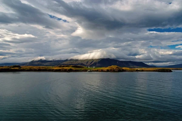 Água do mar na costa montanhosa sob céu nublado em Rejkjavik, Islândia. Mar na paisagem montanhosa. Beleza da natureza selvagem. Tempo e ecologia. Wanderlust e férias — Fotografia de Stock