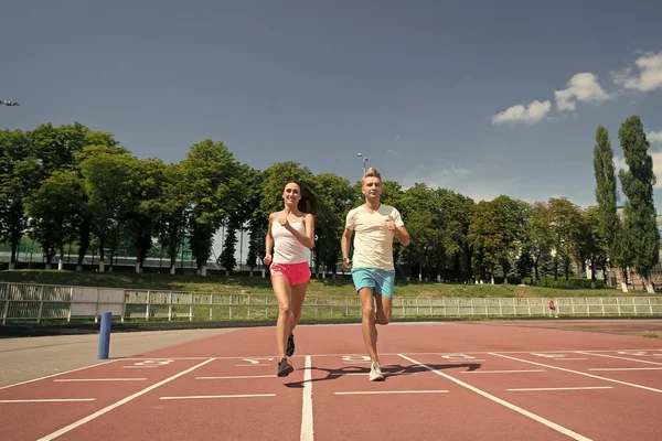 Runner uomo e donna in esecuzione su pista arena — Foto Stock