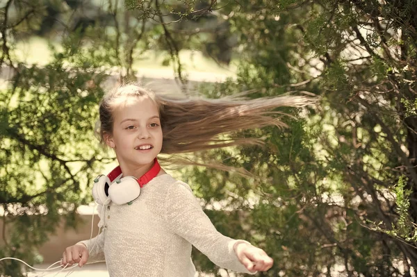 Çocuk dansçı ile uzun saç uçan. Çocuk dans müzik yaz Park. Küçük kız müzik kulaklık açık keyfini çıkarın. Melodi ses ve mp3. Yaz eğlence ve neşe — Stok fotoğraf