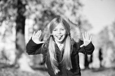 Kız oynak Face yüz kat Güz park tadını çıkarın. Oynak çocuk eğlence. Sıcak ceket açık yürüyüş çocuk sarı uzun saçlı. Çocuk giyim moda ceket kukuleta ile. Sonbahar giyim ve moda kavramı