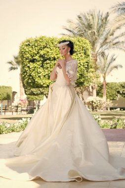 Güzel gelin. Tavsiye ve ipuçları düğün yurtdışında uzmanlar. Şeyler yurtdışında düğün için göz önünde bulundurun. Gelin çok güzel beyaz gelinlik güneşli gün palmiye ağaç arka plan. Düğün töreni tropik ada