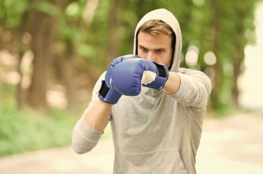 Boks eldivenleri ve doğal peyzaj kaputa adam. Temiz hava boksör egzersiz. Knowckout. Delme adam. Başarı için mücadele. Onun boks becerileri eğitim. Mücadele tarihi. Güç ve enerji