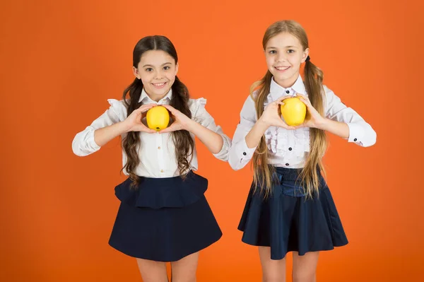 Fresh and tasty. Small girls eating natural vitamin food. Cute schoolgirls holding apples. School children with healthy apple snack. Little girls taking school snack break. Fruits are high in vitamin — Stock Photo, Image