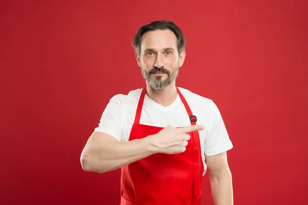 Att ge instruktioner. Laga mat med skägg och mustasch slitage förkläde röd bakgrund. Man mogen koka poserar matlagning förkläde. Fina recept. Idéer och tips. Chief cook och professional kulinariska. Laga mat hemma — Stockfoto