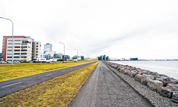 Reykjavík, Island - 12. října 2017: město silnice podél moře na zatažené obloze. Promenáda u moře. Svoboda, perspektivu a budoucnost. Cestování a wanderlust v městské krajině — Stock fotografie