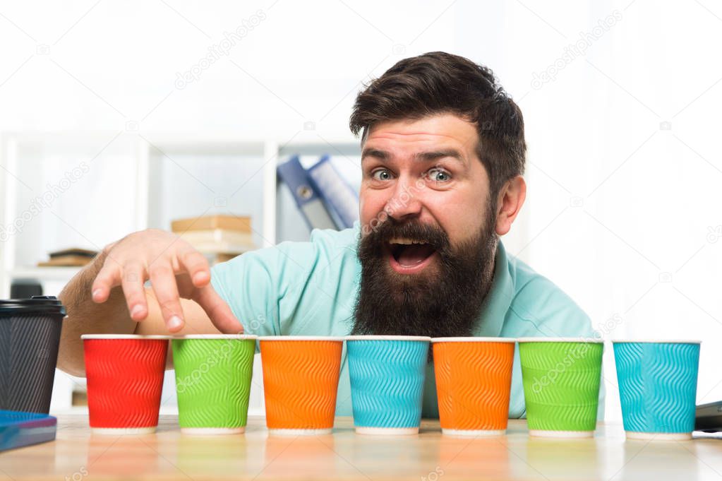 Pick one. Diversity and recycling. Eco paper cup. Coffee to go paper cup. How many cups per day. Choose from alternatives. Man bearded choosing one of lot colorful paper cups. Alternative concept