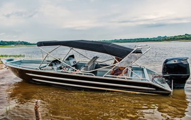 Adam oturup Motorlu tekne veya powerboat Manaus, Brezilya deniz sahilinde demirli. Su ulaştırma araçları ve gemi. Yaz tatili ve deniz seyahat. macera ve keşif