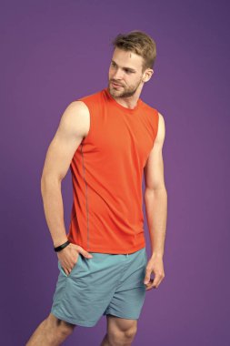 Menekşe arka plan üzerinde atlet. Spor giyim atletik bir adam. Sağlıklı yaşam için kişisel antrenör. Zinde ve kendinden emin. Spor moda eğitim ve egzersiz için. Fitness ve sağlıklı yaşam