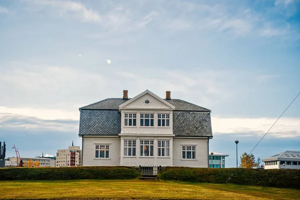 House with green lawn on blue sky in reykjavik, iceland. Architecture, structure and design. Village or small town building, real estate — Stock Photo, Image