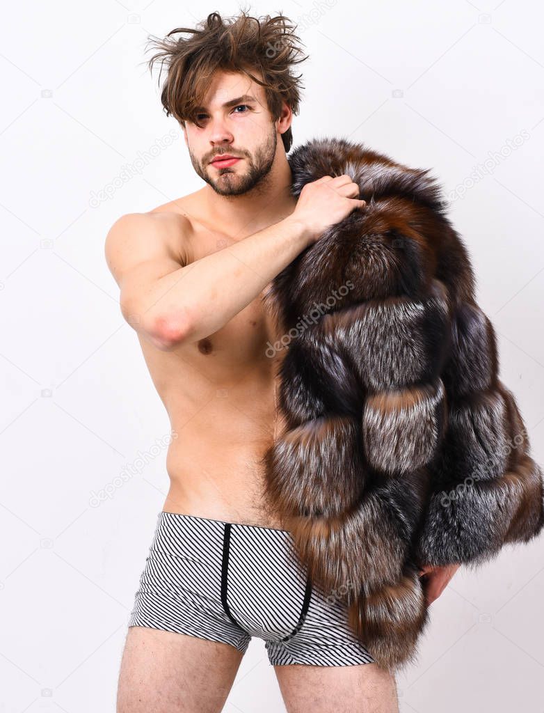 Bachelor rich lover. Guy attractive posing fur coat on naked body. Luxury lifestyle and wellbeing. Luxury status symbol. Sexy sleepy macho tousled hair isolated on white. Richness and luxury concept