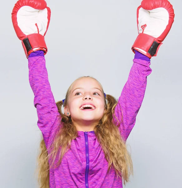 Sport upbringing. Skill of successful leader. Sport upbringing for leader. Girl cute child with red gloves posing on white background. Cute kid with sport boxing gloves. Boxing sport for female