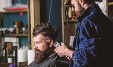 Hipster istemci Başlarken saç kesimi. Kuaför saç kesme makinesi ile sakallı adam, retro berber arka plan saç kesimi üzerinde çalışır. İstemci ense üzerinde kırpma makası kesme saçlı berber. Hippi saç modeli kavramı