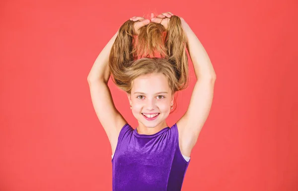 How to make tidy hairstyle for kid. Ballroom latin dance hairstyles. Kid girl with long hair wear dress on red background. Things you need know about ballroom dance hairstyle. Hairstyle for dancer