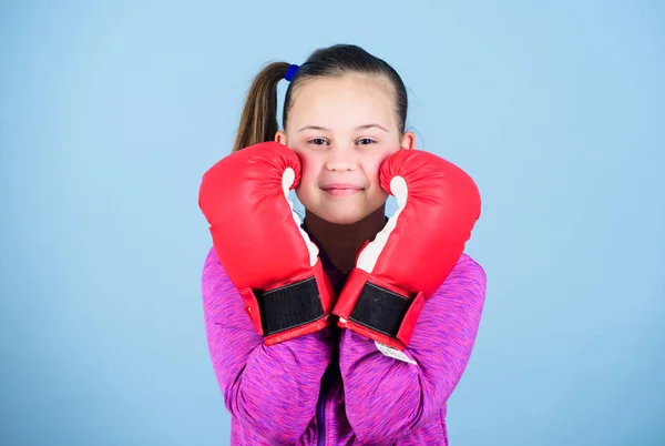 Boxerkind in Boxhandschuhen. Boxerin. Sportliche Erziehung. Boxen sorgt für strenge Disziplin. Mädchen niedlichen Boxer auf blauem Hintergrund. Mit großer Macht kommt große Verantwortung. Entgegen dem Klischee — Stockfoto