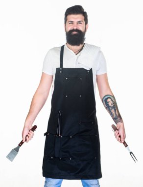 Profesyonel Barbekü. Barbekü çatalı ve spatula elinde olan sakallı adam. Cook Portatif Barbekü yemek araçları kullanarak ızgara. Paslanmaz çelik Barbekü yiyecek hazırlama araçları tutarak hipster