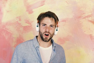 Amerikan yakışıklı adam kulaklıklarla sakallı. Müzikal yaşam tarzı. Neşeli genç dj kulaklık üzerinden dinleme şarkıları. Smartphone ile mavi gözlü şık hippi. Eğlenceli olan Avrupa adam saat