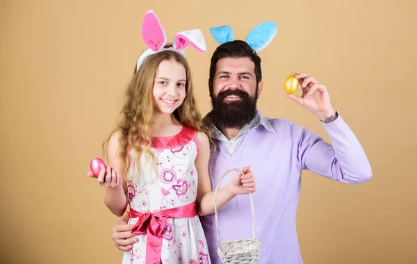 Happy family. Happy family celebrating Easter. Happy father and child with colored Easter eggs. Family of father and daughter smiling in Easter bunny ears. Happy family having fun on Easter. Egg hunt