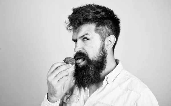 Erotische concept. Mondelinge plezier. Oftewel Hoe smaakt zomer. Man likken zoete berry. Man knappe sexy hipster met lange baard aardbei tong likken. Hipster genieten van sappige rijpe rode aardbei — Stockfoto