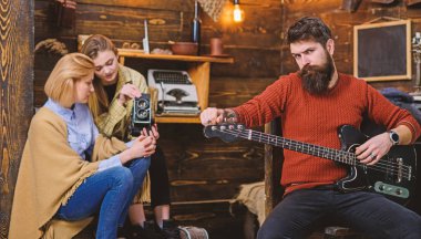 Anne ve Genç kız video kamera üzerinde müzikal performans kaydı. Rock müzisyen insana en sevdiğim enstrüman. Adam gitar çalmak acımasız bakışla sakallı. Melodi prova trendy sakallı