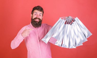 Sakal ve bıyık alışveriş torbaları, kırmızı arka plan işaret olan adam. Mutlu yüz hipster bağımlısı alışveriş veya Alışverişkoliğin. Satış sezon indirimlerle alışveriş adam. Alışveriş kavramı