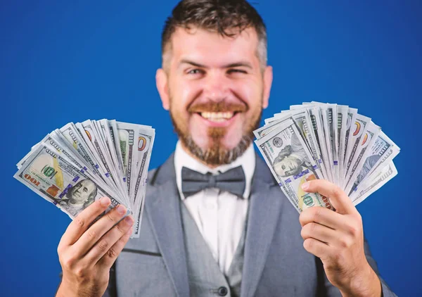 Easy cash loans. Win lottery concept. Businessman got cash money. Get cash easy and quickly. Cash transaction business. Man happy winner rich hold pile of dollar banknotes blue background