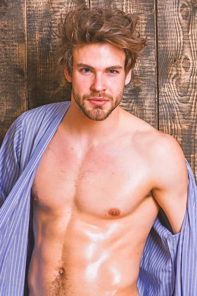 Sexy attractive macho tousled hair on wooden background. Man athlete with fit torso. Sportsman show six pack sexy torso. Bachelor sexy body chest and belly. Guy shimmering skin undressing bathrobe — Stock Photo, Image