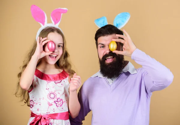 Look forward to celebrating Easter. Family celebration. Father and child with colored Easter eggs. Family of father and daughter in Easter bunny ears. Happy family. Family at annual Easter egg hunt