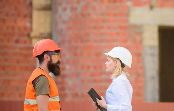 Relations client de construction et industrie de la construction participante. Discuter du plan de progrès. Concept d'industrie de la construction. Femme ingénieur et barbu constructeur brutal discuter des progrès de la construction — Photo