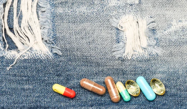 Medicíny a léčby konceptu. Léky na pozadí džínovina. Sada barevných pilulek. Míchání léky. Rychlá léčba. Lék na předpis. Zdravotní péče a nemoci. Dávky a závislost. Drogová závislost — Stock fotografie