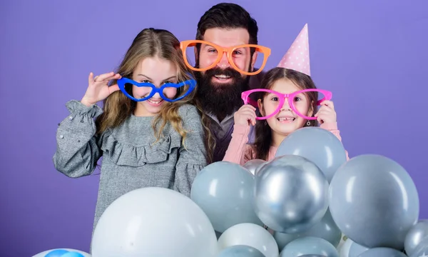 Happy birthday. Having a family celebration. Happy family celebrating birthday party. Family party. Family of father and daughters wearing party goggles. Father and girl children enjoying party time