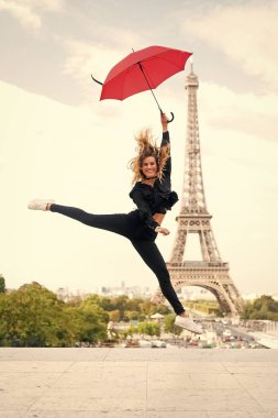 Bayan şemsiye ile Eyfel Kulesi, gökyüzü arka plan ziyaret hakkında heyecanlı. Hayalleri gerçek kavramı oldu. Bayan turist sportif ve aktif Paris şehir merkezinde kadar atlar. Kız turistik zevk yürüyüş ve gezi