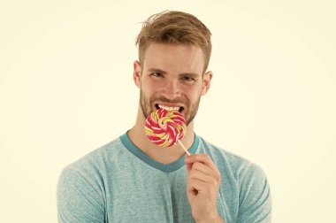 Güçlü dişler. Adam lolipop tutan. Adam dev renkli lolipop izole beyaz arka plan yiyor. Adam kıl tatlılar seviyor. Aşırı şeker götürmek-e doğru kalkınma çürük. Diş Bakımı ve sağlık kavramı