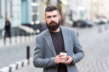 Adam hipster içki kahve kağıt bardak sakallı. İyi bakımlı işadamı kahve arası açık havada kentsel arka plan tadını çıkarın. Düşünceli ama rahat. Yürümek ve taze sıcak kahve keyfini çıkarın. Gevşeme söz konusu