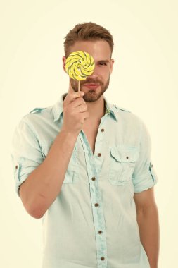 Görüşünü kontrol et. Adam büyük lolipopu gözünün önünde tutuyor. Yoğunlaştırılmış yüz testi beyazları izole etti. Oftalmoloji odasını ziyaret eden bir adam. Görme yeteneğini kontrol etmek için göz doktoruna gitmelisin.