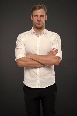 Sana yardım için buradayım. Adam dükkanı danışman kendinden emin ve misafirperver görünüyor. Adam sakin yüz güvenle ile poz silah gri arka plan katlanmış. Kıl dükkanında yardım etmeye hazır adamla