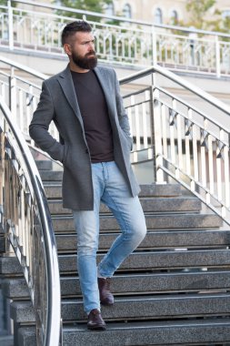 Merdivenlerden aşağı. Havalı günlük kıyafet bahar sezonu. Erkek giyim ve erkek moda konsepti. Erkek sakallı hippi modaya uygun bir ceket ya da ceket. Rahat bir kıyafet. Moda mankeni hippi.