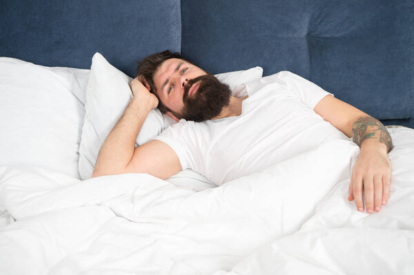 Sleepless night. Sleep disorders concept. Man bearded hipster having problems with sleep. Guy lying in bed try to relax and fall asleep. Relaxation techniques. Violations of sleep and wakefulness