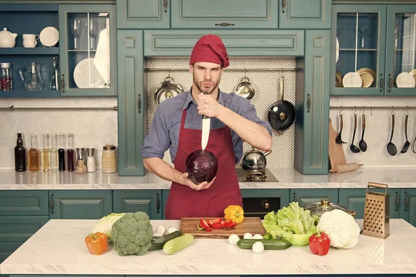 Profesionální kuchař. Šéf učí, jak rychle sekat zeleninu. Nakrájejte potraviny bezpečně a efektivně, ujistěte se, že používáte správné nástroje. Zjistěte, jak správně držet nůž a používat správnou sekací techniku — Stock fotografie