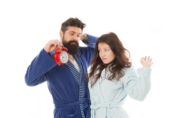 Family morning. Perfect morning concept. Family woke up on time. Couple in love young family in bathrobes stand isolated on white background. Girl with tousled hair and man with clock in hand