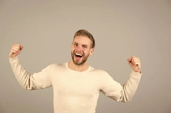 Fröhlicher Sieger. Mann glücklich fröhliches Gesicht posiert mit Muskeln als Sieger. Kerl feiert den Sieg. süßer Geschmack des Ruhms. Mann erfolgreich gut aussehend unrasiert stylischer Macho, grauer Hintergrund — Stockfoto