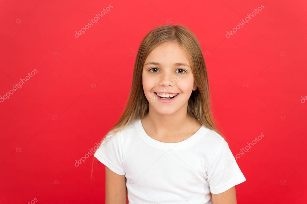 Smiling beauty. Brilliant smile concept. Girl happy smiling face over red background. Emotional kid cute smiling face. Sincere emotion. Cheerful adorable girl smiling. Positive and optimistic