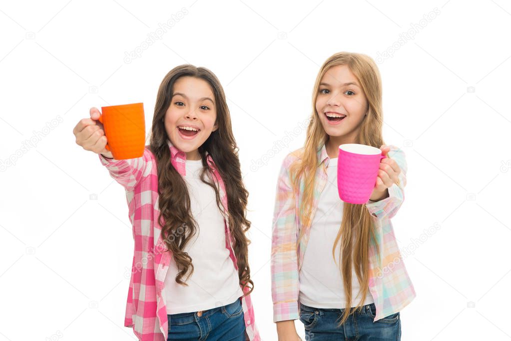 It is tea time. Relaxing with drink. Tea break. Children do not drink enough during school day. Make sure kids drink enough water. Girls kids hold cups. Sisters hold mugs. Drinking tea while break