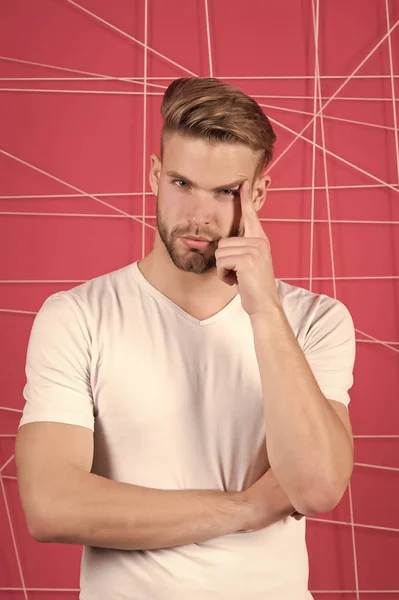 Concetto di mascolinità. Uomo con setole sul viso premuroso, sfondo rosa. L'uomo con la barba o il ragazzo non rasato sembra bello e ben curato. Ragazzo barbuto e attraente con acconciatura — Foto Stock