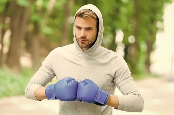 Я готов сражаться. Мужчина спортсмен на концентрированном лице в спортивных перчатках, практикующий боксерский пунш, природный фон. Голова боксера готова к бою. Спортсмен тренируется в боксёрских перчатках — стоковое фото