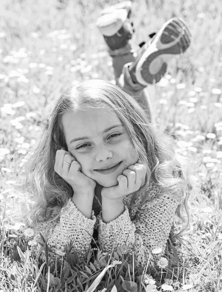 Concepto Heyday. Chica en la cara sonriente pasar el ocio al aire libre. El niño disfruta del clima soleado de primavera mientras está acostado en el prado. Chica acostada en la hierba en la parcela de hierba, fondo verde —  Fotos de Stock