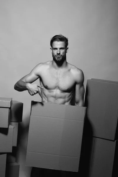 Loader with serious face covers nudity, points to box