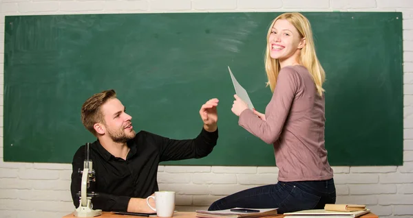 Mostrando uma dedicação à educação. Homem e mulher de volta à escola. Educação secundária. Professora bonita e bonito professor de notas papéis. Estudantes universitários. Casal estudando em sala de aula — Fotografia de Stock