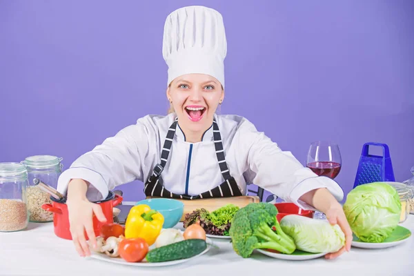 Lets start cooking. Woman chef cooking healthy food. Gourmet main dish recipes. Delicious recipe concept. Girl in hat and apron. Cooking healthy food. Fresh vegetables ingredients for cooking meal