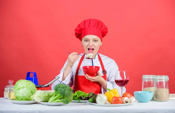 Dieting concept. Eat healthy. Girl wear hat and apron try meal taste. Healthy ration. Woman professional chef hold bowl and spoon. Free healthy vegetarian and vegan recipes. Healthy raw food — 图库照片