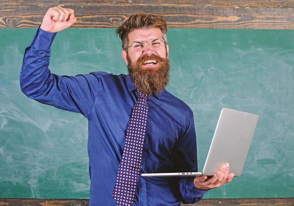 Teste de aprovação online. Conceito de educação à distância. Professor barbudo homem com laptop moderno passou teste de fundo quadro-negro online. Professora Hipster óculos detém laptop passou verificação de conhecimento de distância — Fotografia de Stock